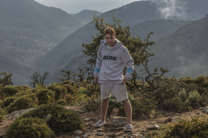 Ein Mann mit ACON Hoodie in einer Waldlandschaft