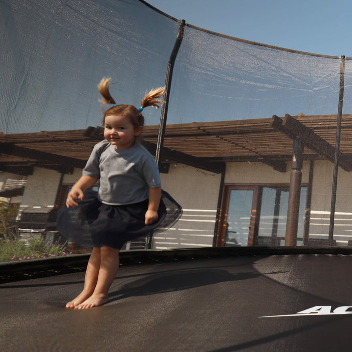 Ein kleines Kind springt auf einem Acon-Trampolin.